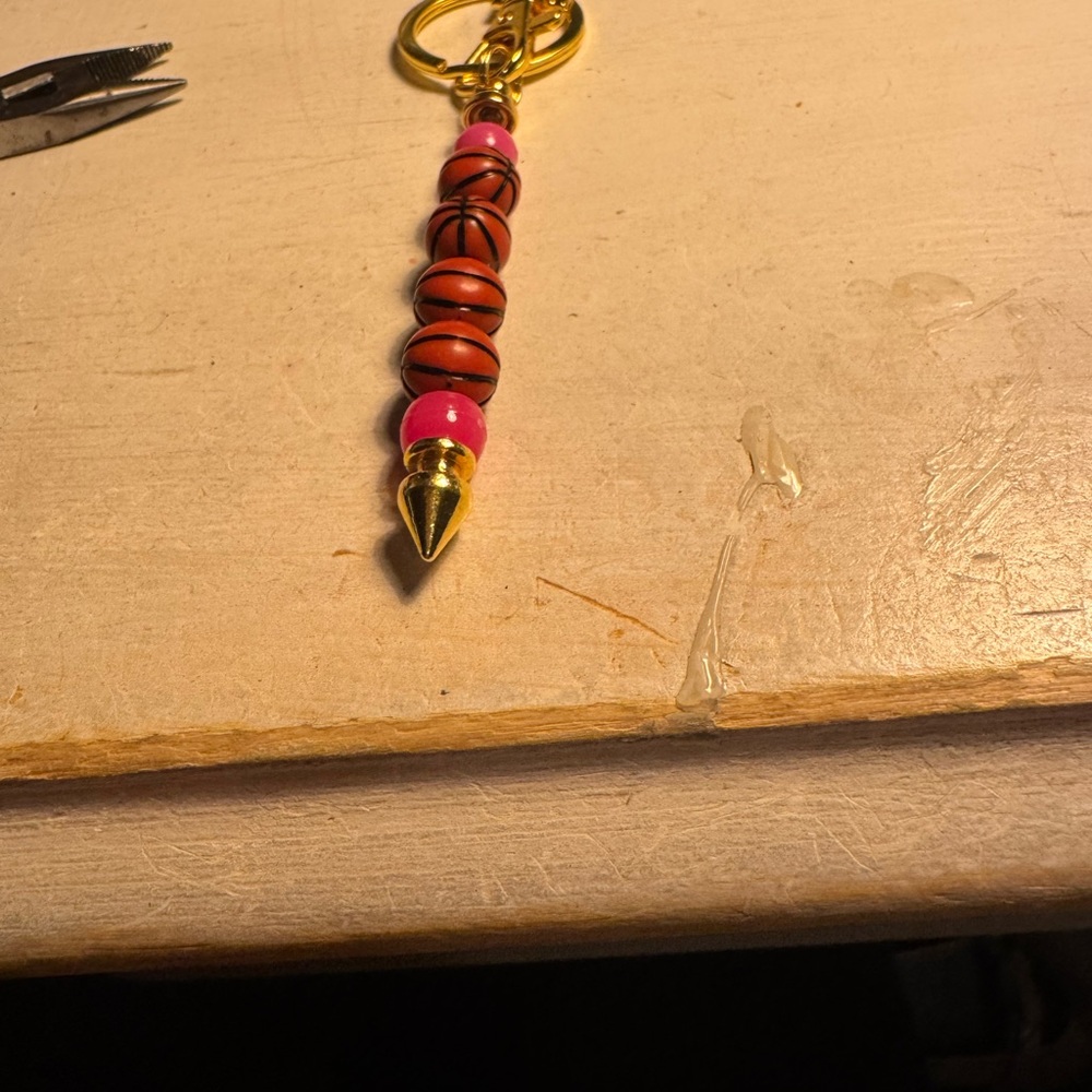 Gold tone march madness keychain with pink head and basketball beads